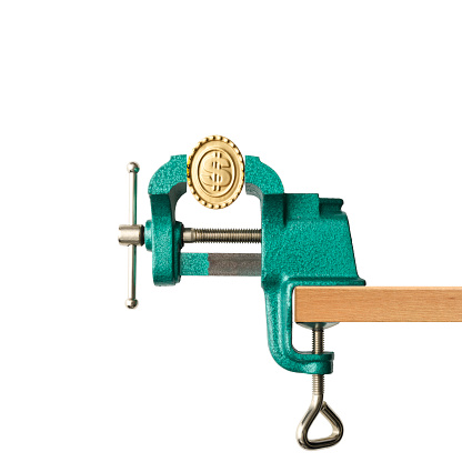 Front view of apply pressure to dollar gold coins with a vise grip against white background.