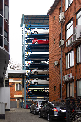 Krasnodar, Russia - February 20, 2020: Multi-level automatic Parking with cars between houses and office buildings