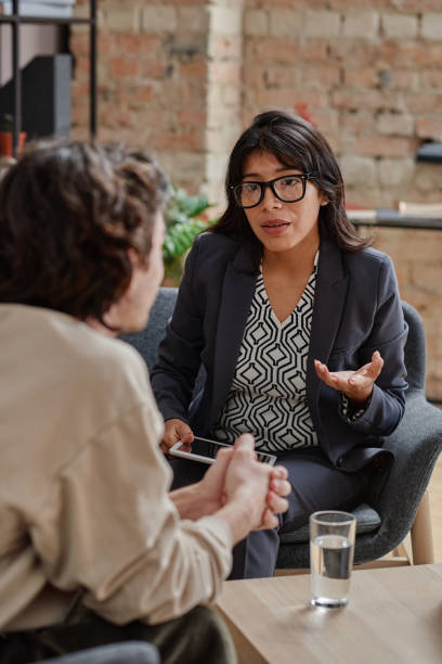istock Vertical medium shot of unrecognizable young man treating depression with help of professional psychotherapist listening to her suggestions 1359467267