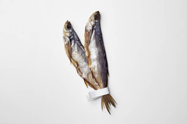istock Two jerked or dried salted sabrefish with paper labels on tails isolated on white 1359468703