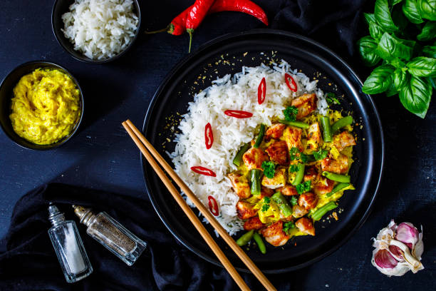 istock Roast chicken meat, white rice and vegetables on wooden table 1359472130