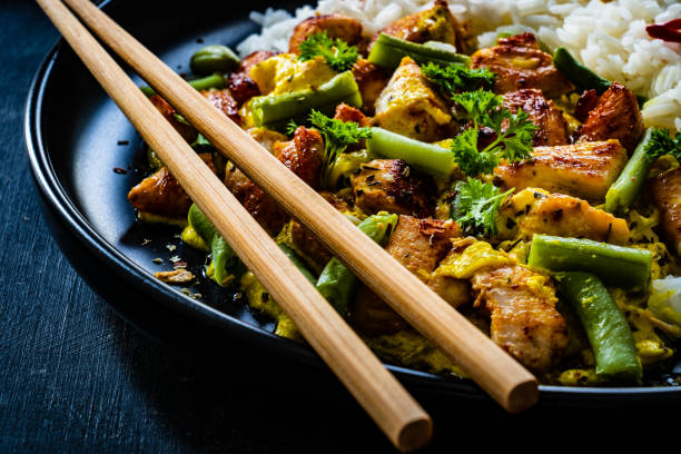 istock Roast chicken meat, white rice and vegetables on wooden table 1359472151