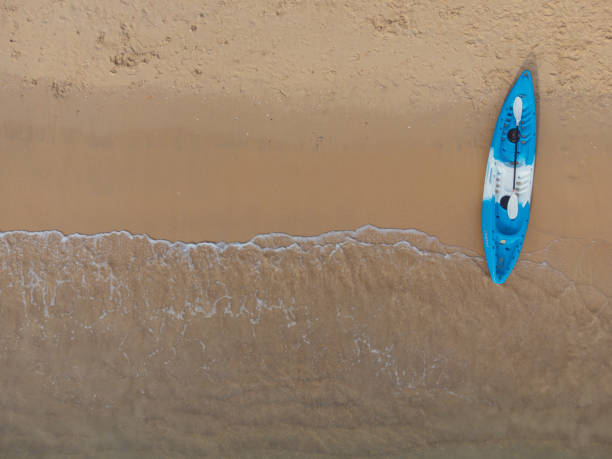 istock Kayak boat on the sand beach with wave marks 1359473537
