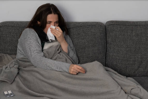 istock sick young girl lying on the sofa at home 1359474734