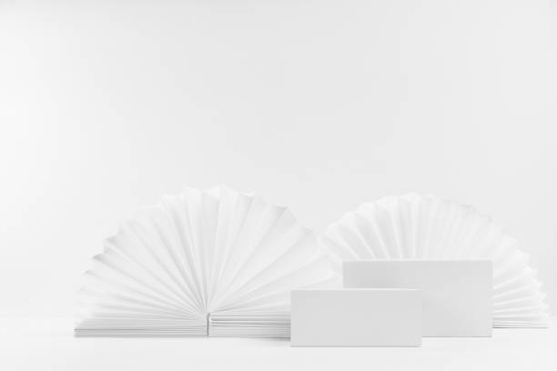 istock Set of two white box podiums on light abstract scene mockup as showcase for displaying, presentation cosmetic product, goods with asian round ribbed paper fans as decor in simple minimalistic style. 1359476486