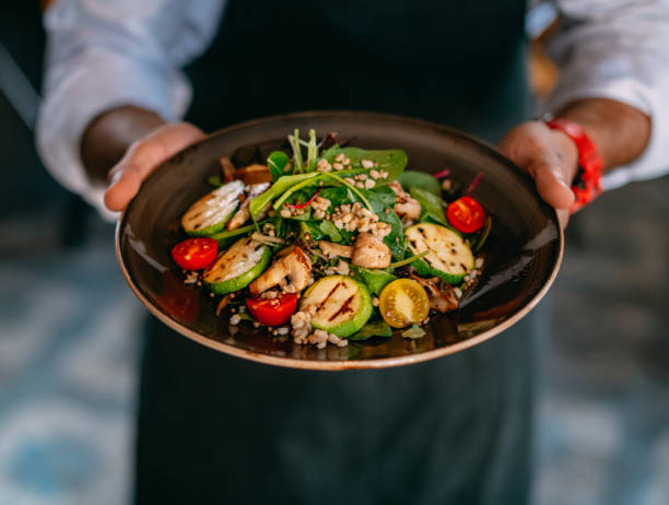 istock Chef Offers His Prepared Vegan Salad 1359478474
