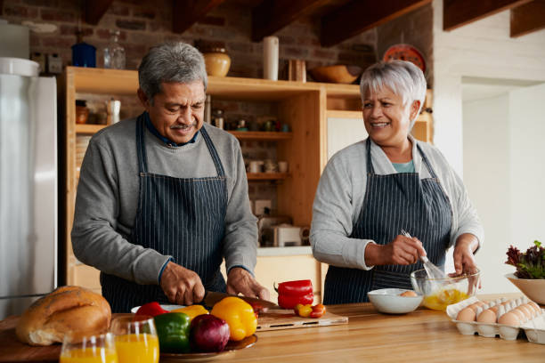 istock Multi-cultural elderly couple happily preparing meal in modern kitchen. Healthy retired lifestyle at home 1359480417