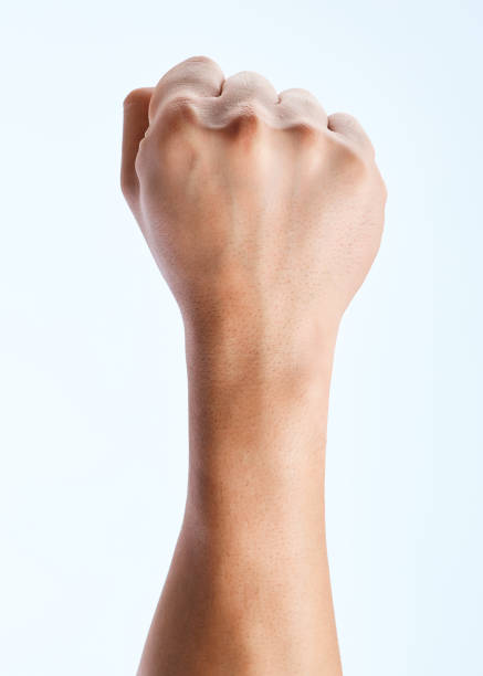 Shot of an unrecognizable man holding his fist up against a white background Humanity, unite anonymous activist network stock pictures, royalty-free photos & images