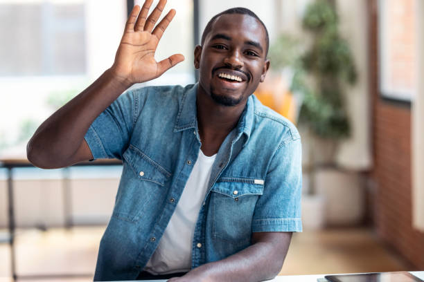 istock Afro-american business man entrepreneur looking at camera while waving hand in a modern startup. 1359482793