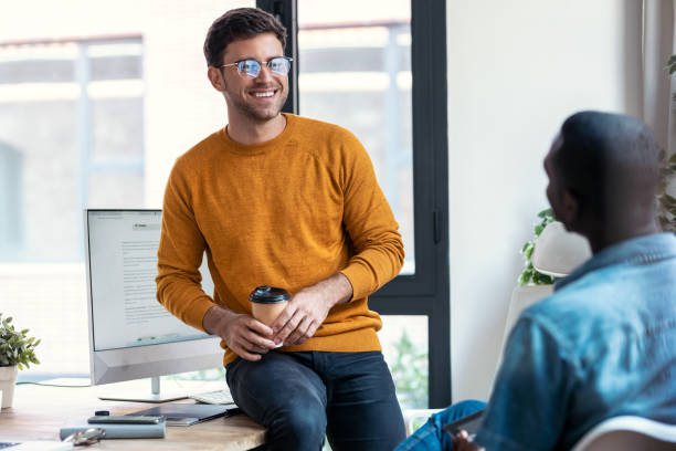 istock Two graphic designer taking a break while talking and having fun together in modern startup office. 1359482926