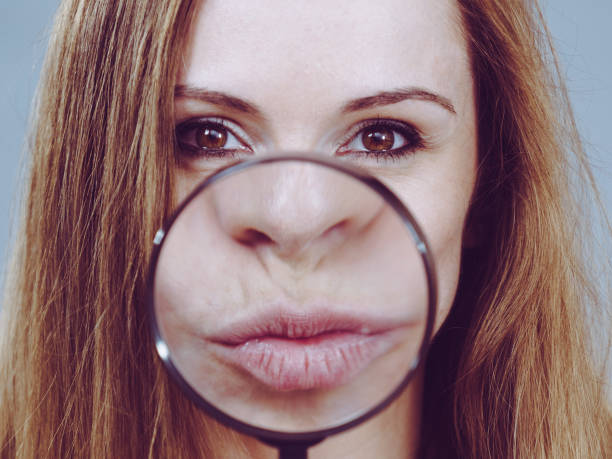 istock Woman showing lips in magnifer 1359483819