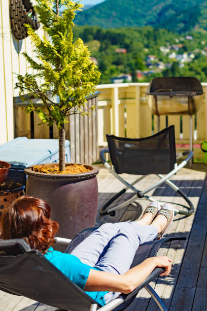 istock Woman relaxing in chair on veranda. 1359484009