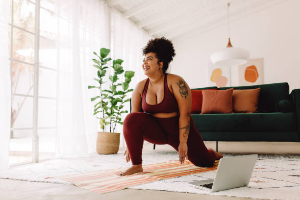 istock Fitness woman stretching at home using laptop 1359484022