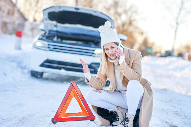 junge frau mit autoproblemen im winter - emergency sign winter driving emergency services stock-fotos und bilder