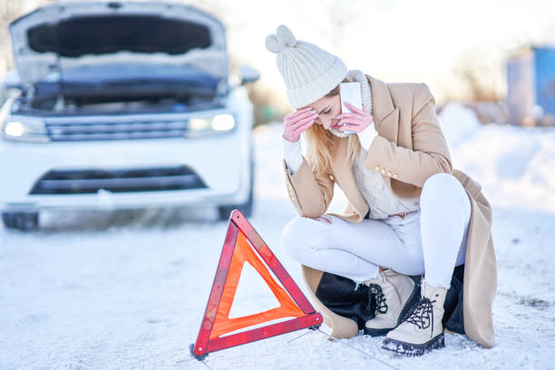 junge frau mit autoproblemen im winter - emergency sign winter driving emergency services stock-fotos und bilder
