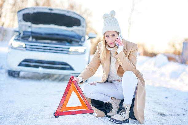 frau mit notfalldreieck - emergency sign winter driving emergency services stock-fotos und bilder