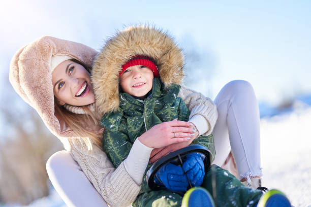 istock Nice happy family having fun on winter snow 1359486102