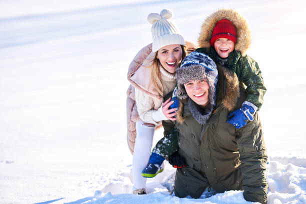 istock Nice happy family having fun on winter snow 1359486295