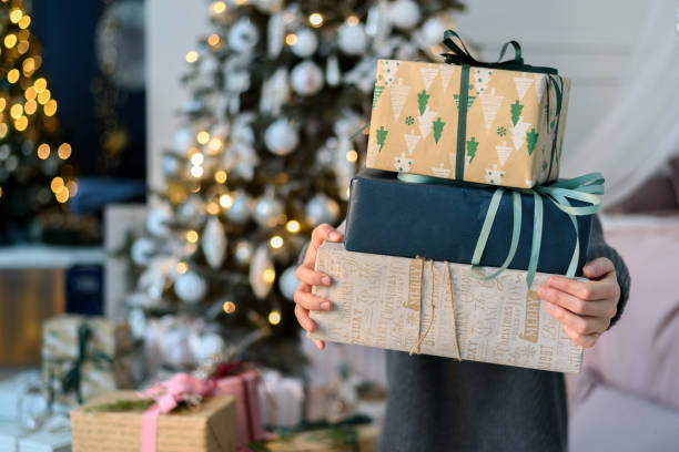 istock Woman holding gift boxes with Christmas decorations 1359487153