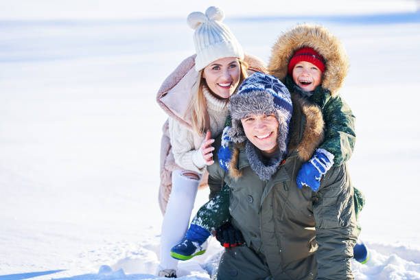 istock Nice happy family having fun on winter snow 1359487211