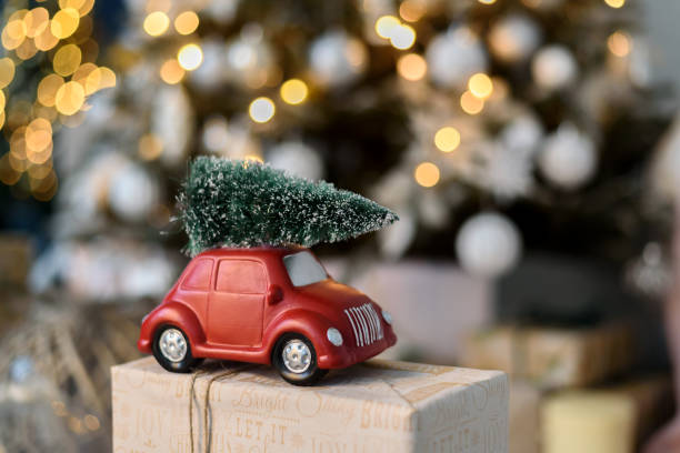istock Unrecognised red toy car with Christmas tree on roof 1359487338