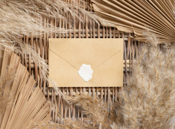 istock Boho sealed envelope on a wattled table with dry palm leaves and pampas grass 1359487355