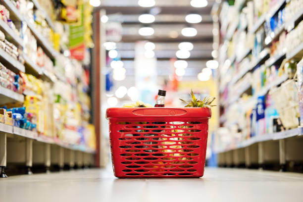 Shot of a shopping basket on the floor of a grocery store The aisle of goodnes market retail space stock pictures, royalty-free photos & images