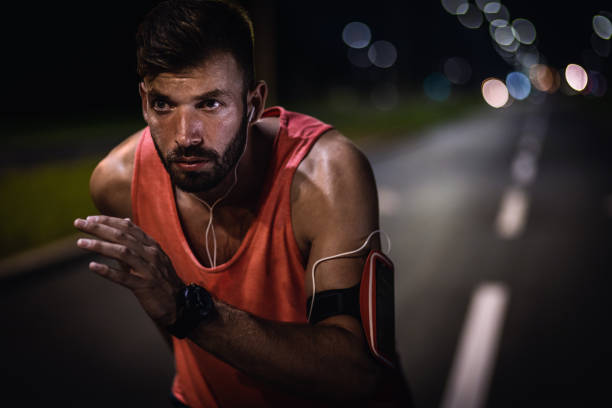 istock Man running through the city at night. 1359488802