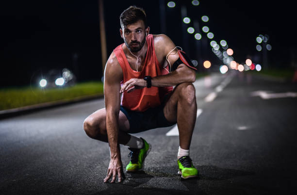 istock Man running through the city at night. 1359488923