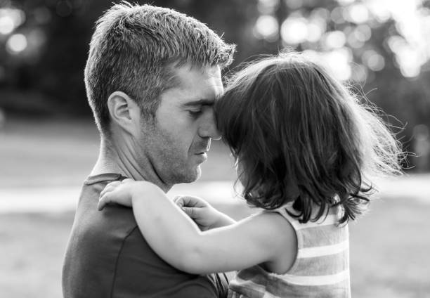 Photo portrait of father and son, isolated on white background. Father holding his son and kissing him in a forehead
