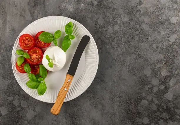 Vegetarian appetizer, Tomatoes, and Burrata cheese with basil and olive oil. Italian food. Flat lay, copy space.