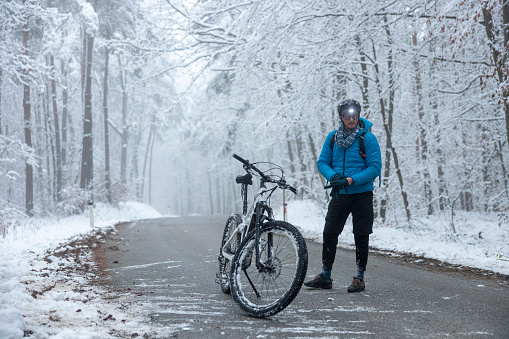 Male biker standing outdoors in winter nature.