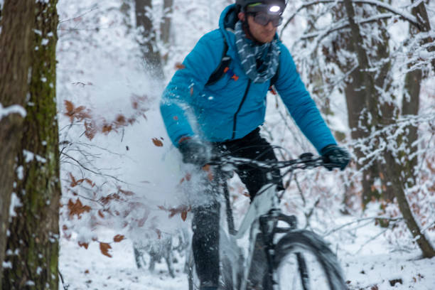 istock Man rides ebike through the snowy bushes at high speed 1359492929