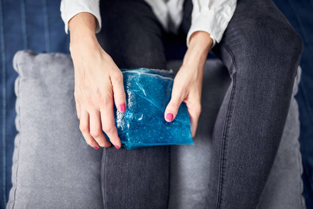 istock Woman with spasm, cramp, sprained, dislocated knee, ruptured tendon and joint pain, using cold gel pack at home. 1359493744