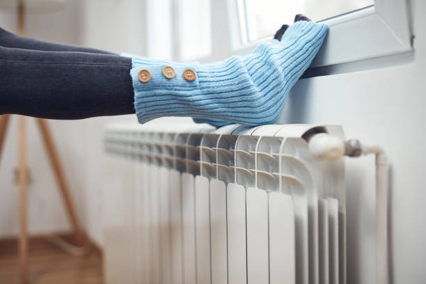 istock Woman's feet with woolen socks, enjoying inside home on the radiator. 1359493759
