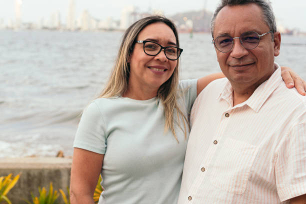 istock Smiling husband and wife standing in park 1359494402