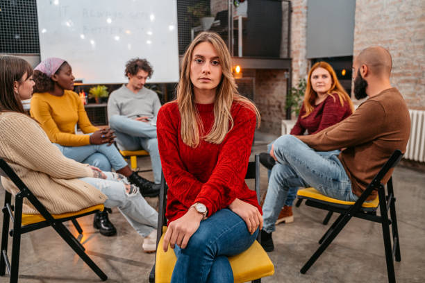 istock Young woman at group therapy session 1359495501