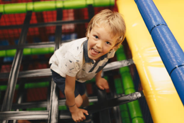 istock Happy Boy Having Fun In Play Area. Elementary Age Kid Playing on Play Centre Construction. Amusement Park Attractions For Kids 1359495782