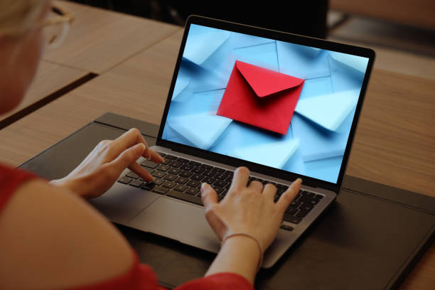 istock E-mail marketing.Woman using laptop with envelope 1359501951