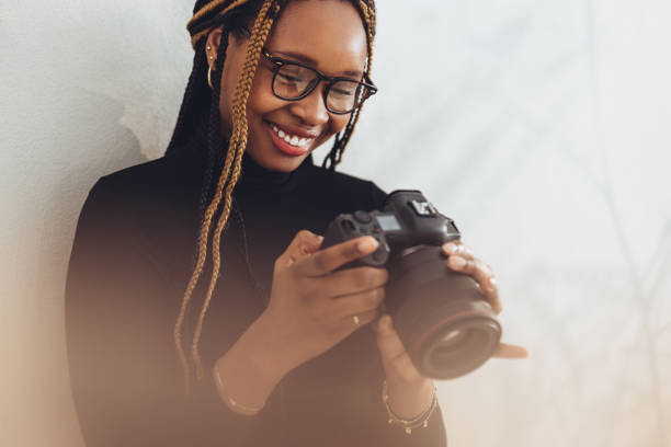 istock Woman setting up her dslr camera 1359504487