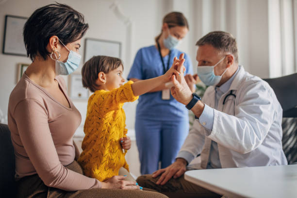 mutter und tochter beim kinderarzt - nurse high five mask stock-fotos und bilder