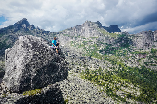 Hiker on top of a rock with a beautiful view of Ergaki natural park