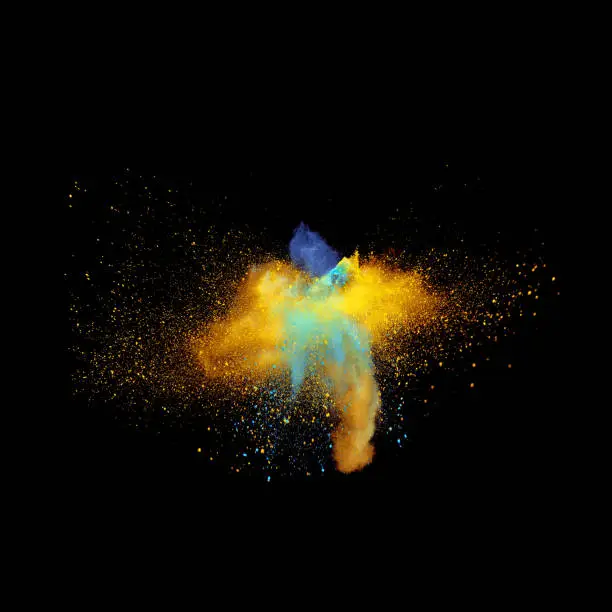 A bizarre form of golden glitter and blue powder paint explode in front of a black background to give off fantastic colors and forms.