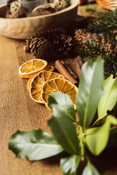 Female making a Christmas wreath in a DIY - Do It Yourself - work at home on a wooden table top with vintage scissors and tools.