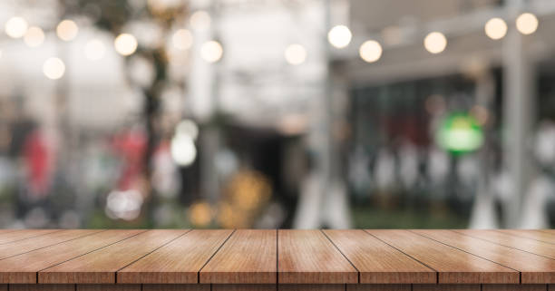 istock Empty wooden table top with lights bokeh on blur restaurant background. 1359510008