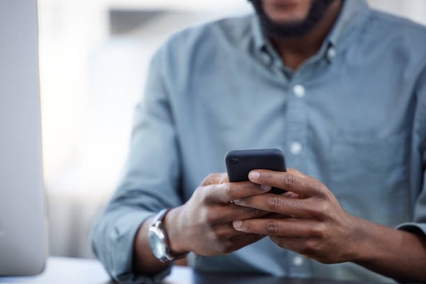 istock Shot of a unrecognizable male using a phone at work in a modern office 1359511466