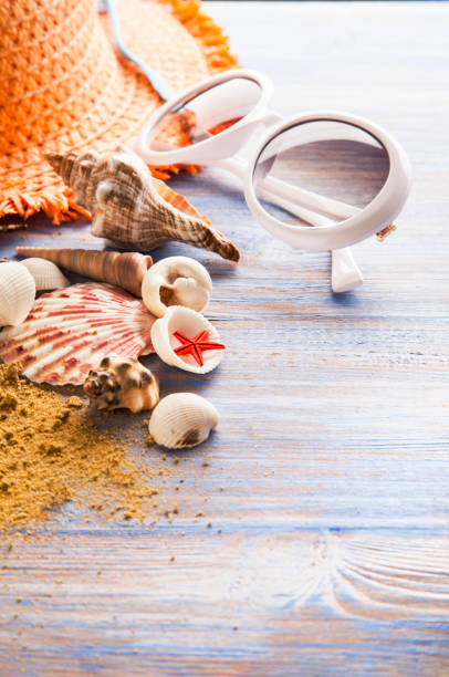 istock beach accessories glasses hat cockleshells on wood deck. 1359513832
