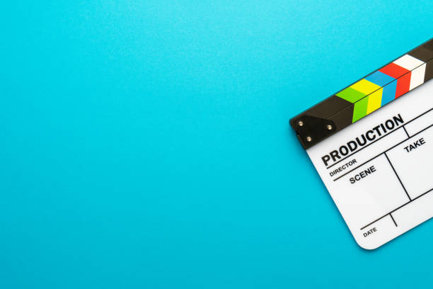 istock Top view of white clapperboard over turquoise blue background and copy space 1359514545