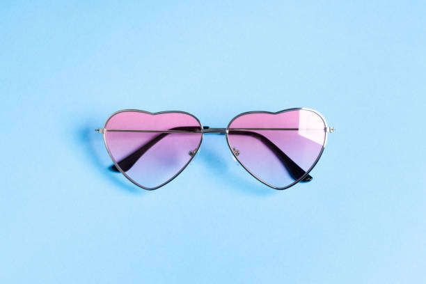 istock Heart shape pink sunglasses on blue background 1359516235