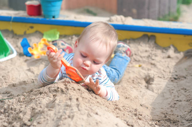 Toddler activity on playground in sandbox.